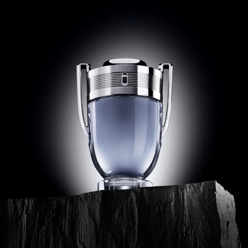 Показана е бутилка на мъжката тоалетна вода Rabanne Invictus EDT от Paco Rabanne с декоративен капак и елегантен дизайн.