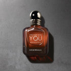 Парфюмна вода за мъже Giorgio Armani Stronger With You Absolutely EDP, бутилка и ароматен дизайн на фона.