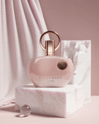 Една жена държи бутилка Afnan Supremacy Pink EDP парфюмна вода за жени с розов дизайн и флорални нотки.